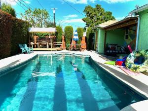 a swimming pool with blue water in a yard at Endless summer in LA *HEATED POOL/HOT TUB/CABANA* in Los Angeles