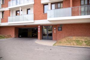 a brick building with a parking lot in front of it at Maya's Flats & Resorts 52 - Aura 40 in Gdańsk