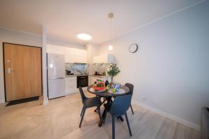 a kitchen and dining room with a table and chairs at Maya's Flats & Resorts 52 - Aura 40 in Gdańsk