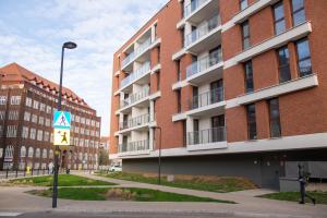 a street sign in front of a tall building at Maya's Flats & Resorts 52 - Aura 40 in Gdańsk