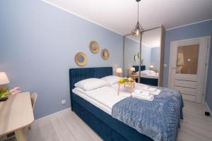 a blue bedroom with a bed and a mirror at Maya's Flats & Resorts 52 - Aura 40 in Gdańsk