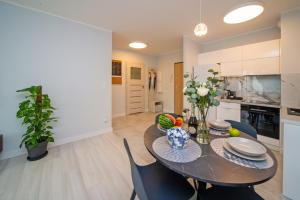 a kitchen and dining room with a table and chairs at Maya's Flats & Resorts 52 - Aura 40 in Gdańsk