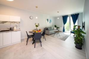 a kitchen and living room with a table and chairs at Maya's Flats & Resorts 52 - Aura 40 in Gdańsk