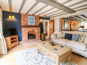a living room with a couch and a fireplace at The White Cottage in Burton upon Trent