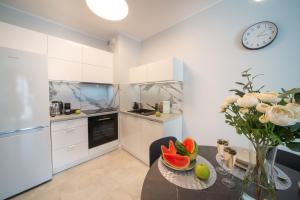 a kitchen with a table and a clock on the wall at Maya's Flats & Resorts 52 - Aura 40 in Gdańsk