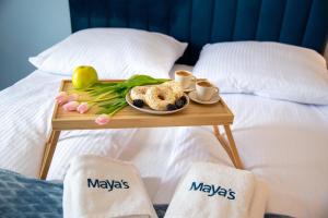 a tray with a plate of food on a bed at Maya's Flats & Resorts 52 - Aura 40 in Gdańsk