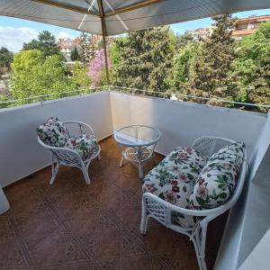 a balcony with chairs and a table and an umbrella at хотел Кристиан in Sozopol