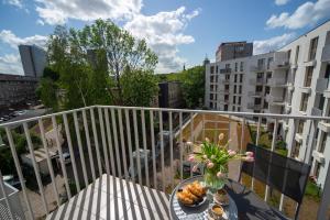 a balcony with a table with a vase of flowers at Maya's Flats & Resorts 52 - Aura 40 in Gdańsk
