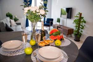 a table with plates and glasses and fruit on it at Maya's Flats & Resorts 52 - Aura 40 in Gdańsk