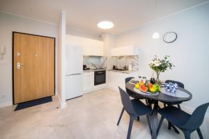 a kitchen and dining room with a table and chairs at Maya's Flats & Resorts 52 - Aura 40 in Gdańsk