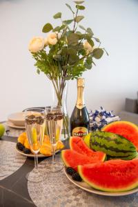 a table with two glasses of wine and a plate of fruit at Maya's Flats & Resorts 52 - Aura 40 in Gdańsk
