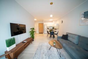 a living room with a blue couch and a table at Maya's Flats & Resorts 52 - Aura 40 in Gdańsk