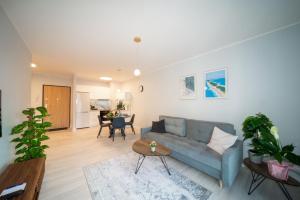 a living room with a blue couch and a table at Maya's Flats & Resorts 52 - Aura 40 in Gdańsk
