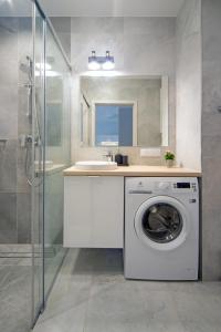 a bathroom with a washing machine and a sink at Maya's Flats & Resorts 52 - Aura 40 in Gdańsk