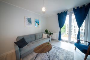 a living room with a couch and a table at Maya's Flats & Resorts 52 - Aura 40 in Gdańsk