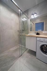 a bathroom with a washing machine and a sink at Maya's Flats & Resorts 52 - Aura 40 in Gdańsk +34 photos