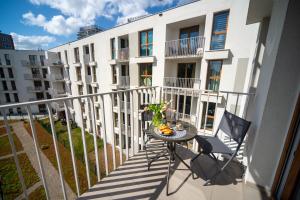 a balcony with a table and chairs and a building at Maya's Flats & Resorts 52 - Aura 40 in Gdańsk
