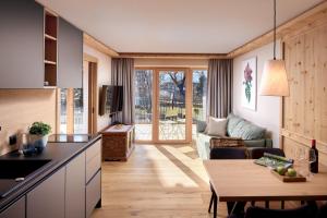 eine Küche und ein Wohnzimmer mit einer Couch und einem Tisch in der Unterkunft Natur Resort RISSBACHER in Stumm