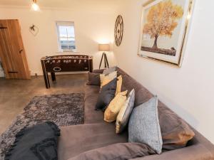 uma sala de estar com um sofá castanho com almofadas em Fell Briggs Cottage em Redcar