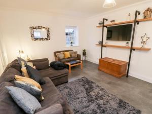 uma sala de estar com um sofá e uma televisão em Fell Briggs Cottage em Redcar