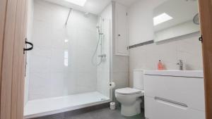 a white bathroom with a shower and a toilet at Fell Briggs Cottage in Redcar +25 photos