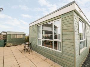 a green house with a large window on a patio at The Lodge in South Molton