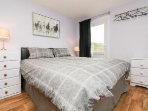 a white bedroom with a bed and a window at The Lodge in South Molton