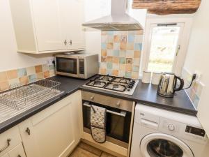 a kitchen with a stove top oven next to a microwave at The Annexe in Keighley