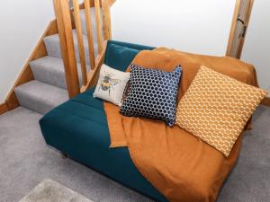 a couch with pillows on it next to a staircase at The Annexe in Keighley