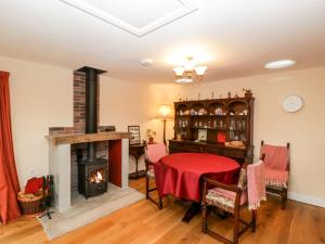 sala de estar con mesa y chimenea en Vine Lodge, en Martock