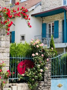 VillersexelにあるManoir Saint-Pierreのピンクの花と柵のある家