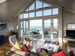 a living room with a couch and a large window at Drishti in Polzeath