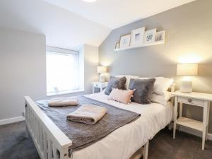 a bedroom with a large bed with pillows on it at Driftwood Terrace in Porthmadog