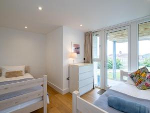 a bedroom with two beds and a window at Drishti in Polzeath