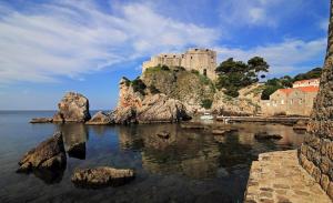 a castle sitting on top of a hill next to the water at Hostel Angelina Old Town in Dubrovnik