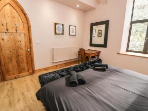 1 dormitorio con 1 cama grande y puerta de madera en Greystones Chapel, en Caernarfon