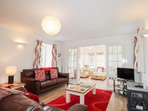 a living room with a couch and a tv at Redburn Steading in Nairn