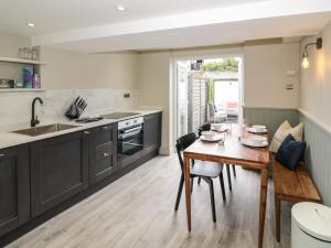 a kitchen with black cabinets and a wooden table at 5 Bull Street in Stratford-upon-Avon