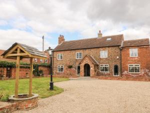 an old brick building with a gazebo in front of it at Cobblers Cottage in Selby