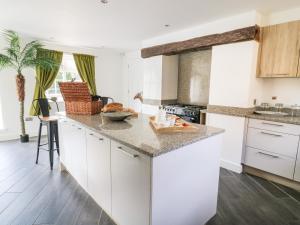 a kitchen with white cabinets and a counter top at Cobblers Cottage in Selby