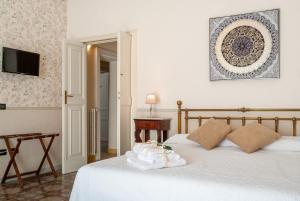 1 dormitorio con 1 cama con sábanas blancas y mesa en B&B Risveglio col Rosone en Lecce