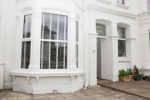 a white building with a window with blinds on it at Apartment 2 in Southsea