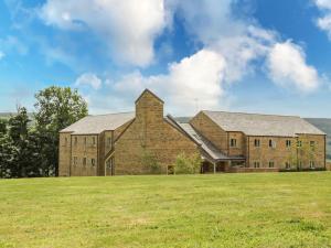 a large brick building on a grass field at Myddelton Grange in Ilkley