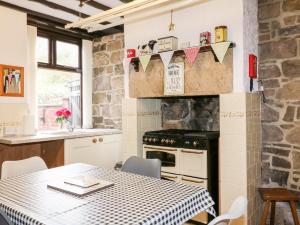 uma cozinha com uma mesa e uma parede de pedra em Halfways em Belper