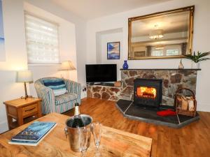 a living room with a fireplace and a table at Ludgvan Cottage in Gorran Haven