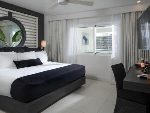 a bedroom with a bed and a desk and a chair at S Hotel Jamaica - All Inclusive - Boutique Hotel in Montego Bay