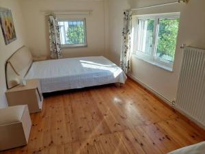 Schlafzimmer mit einem Bett und Holzboden in der Unterkunft Anna's House in Anavyssos