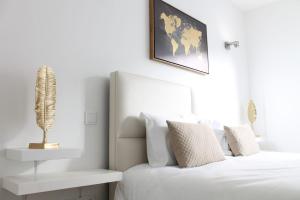um quarto com uma cama branca e uma planta na parede em Villarit Porto em Gondomar