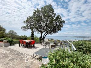 patio ze stołem, krzesłami i drzewem w obiekcie Villa IBIZA w mieście Les Issambres