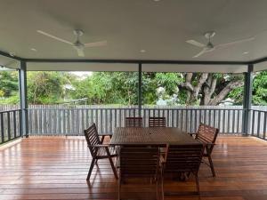a wooden deck with a table and chairs on it at Spacious 4 Bedroom House in Townsville